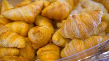 Un plateau contenant un assortiment de viennoiseries, notamment des croissants et d’autres produits de boulangerie.
