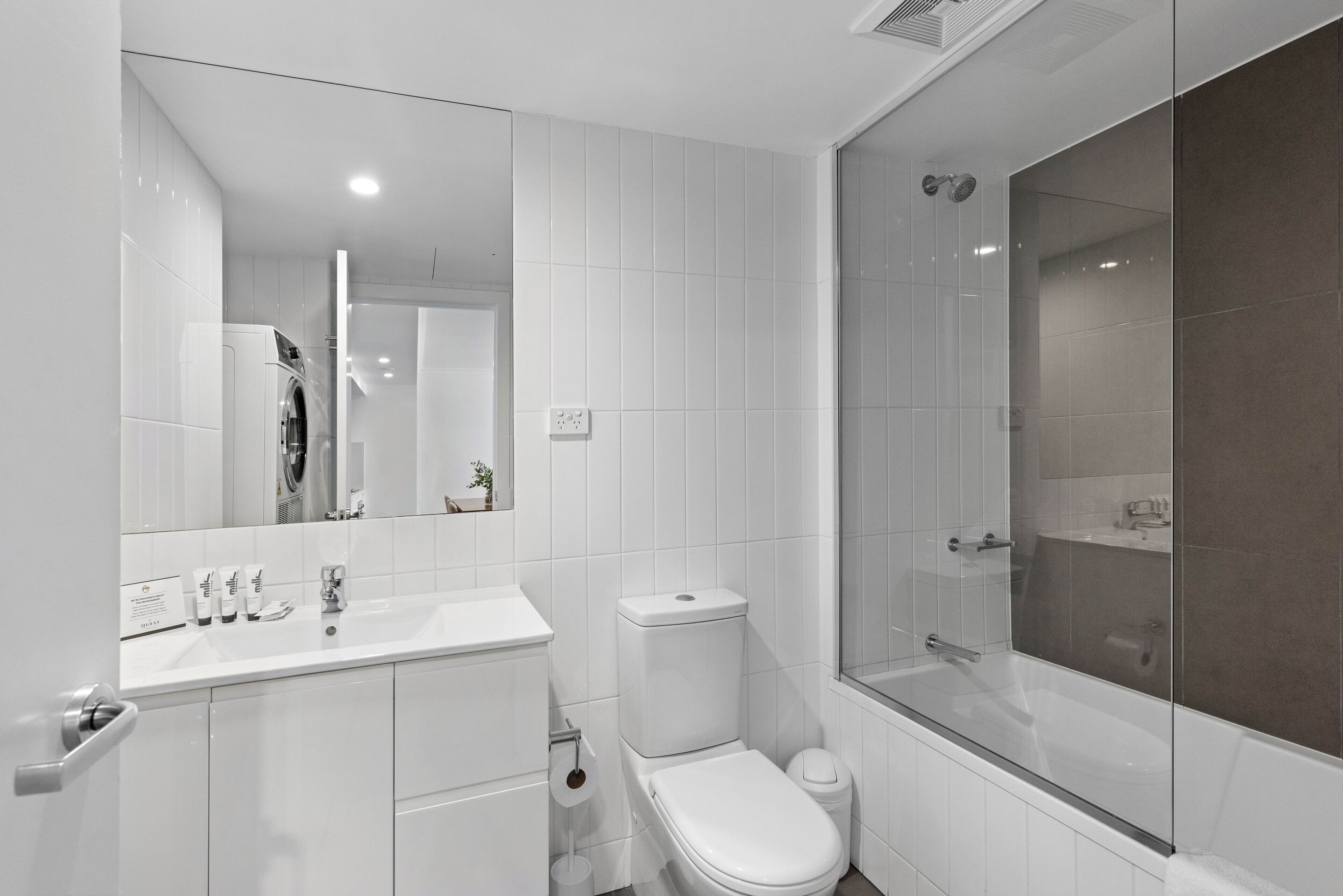 Een moderne badkamer met een wit wastafel, toilet en bad.
