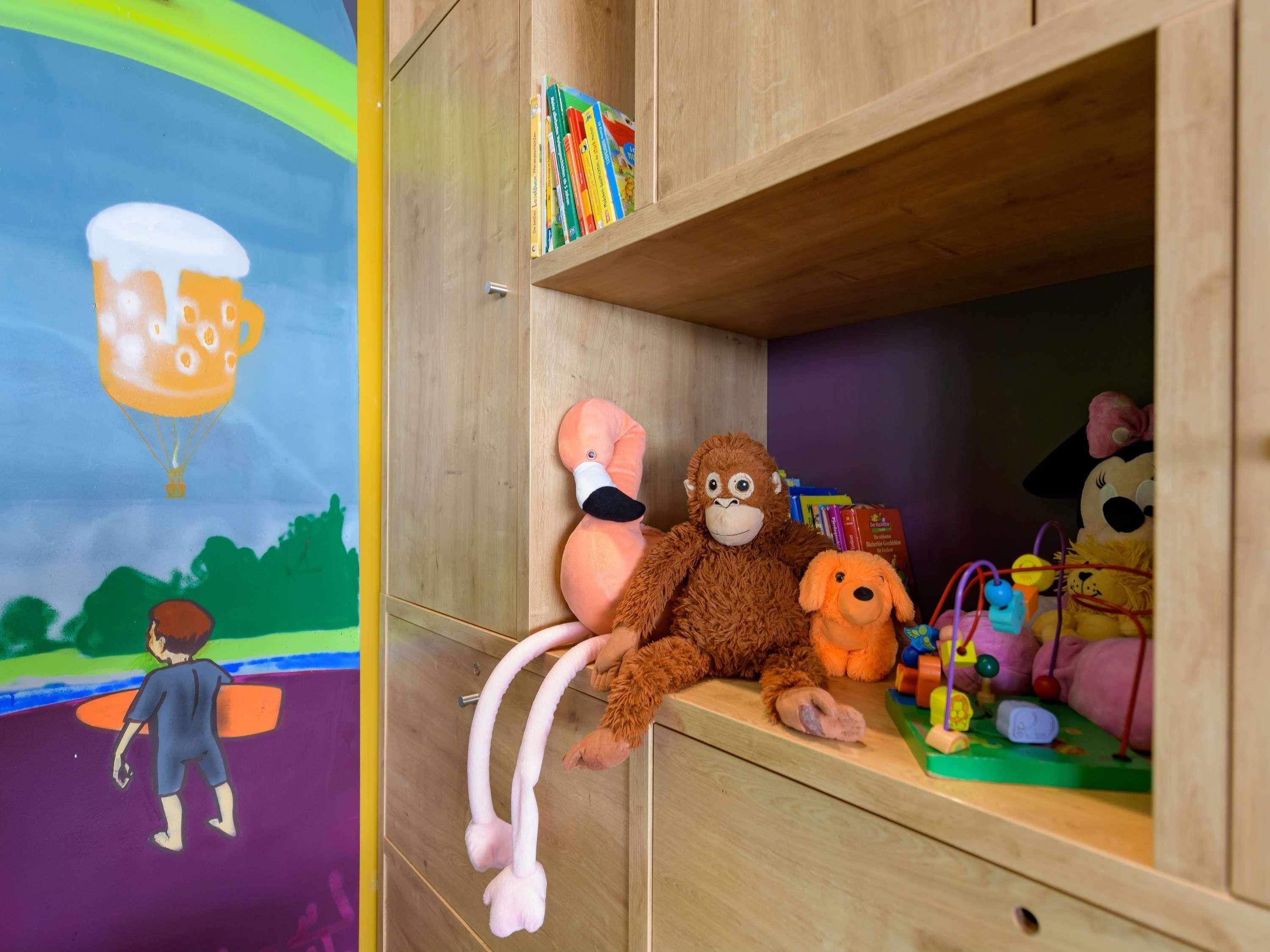 Een houten kastje met boeken en knuffeldiertjes.