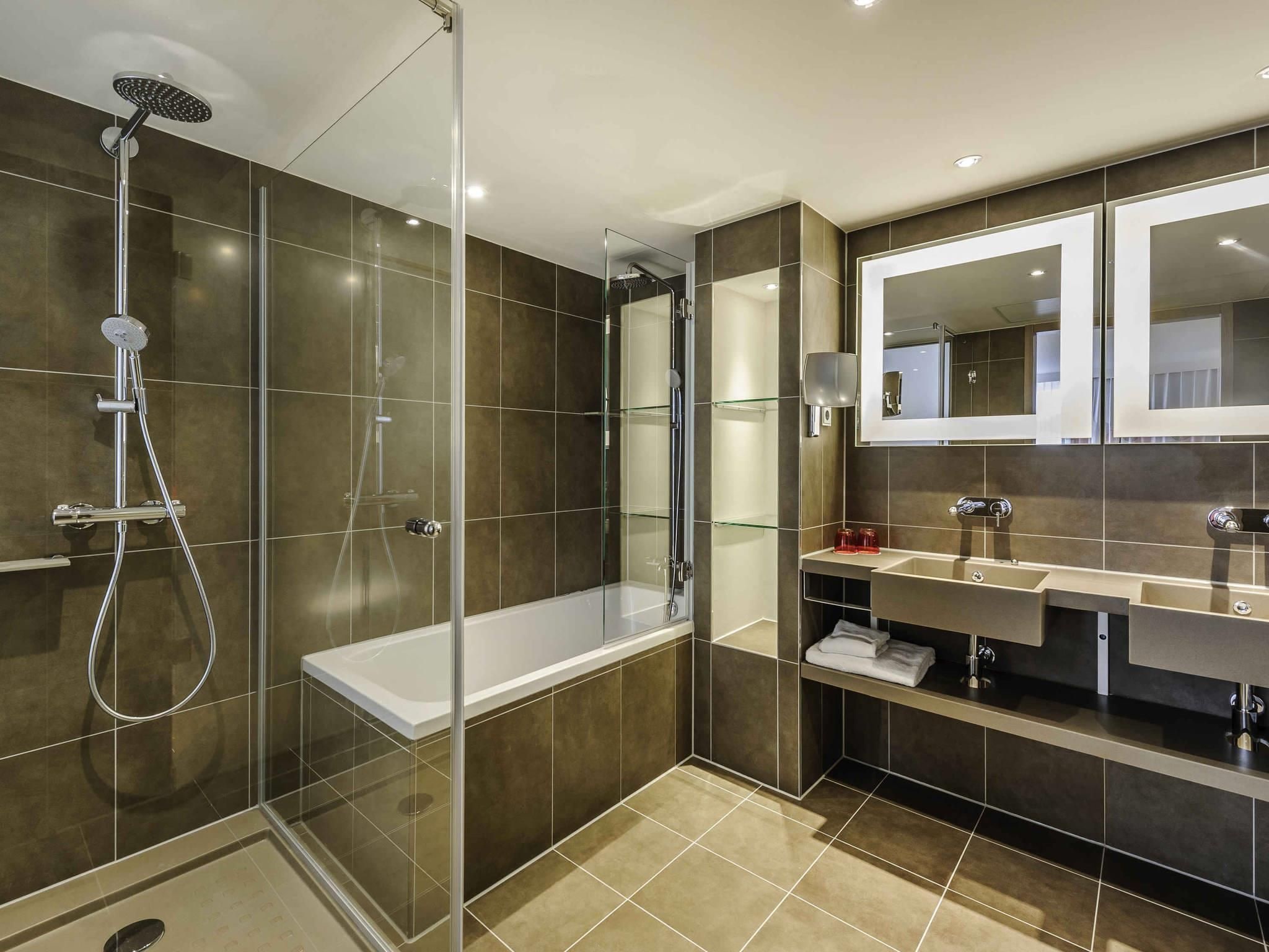 A modern bathroom with a glass-enclosed shower, a standalone bathtub, and a vanity with a mirror.