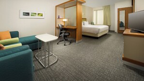 A hotel room with a bed, a desk with a chair, a small table, a sofa, and a television. - SpringHill Suites Bridgeport Clarksburg (Bridgeport)