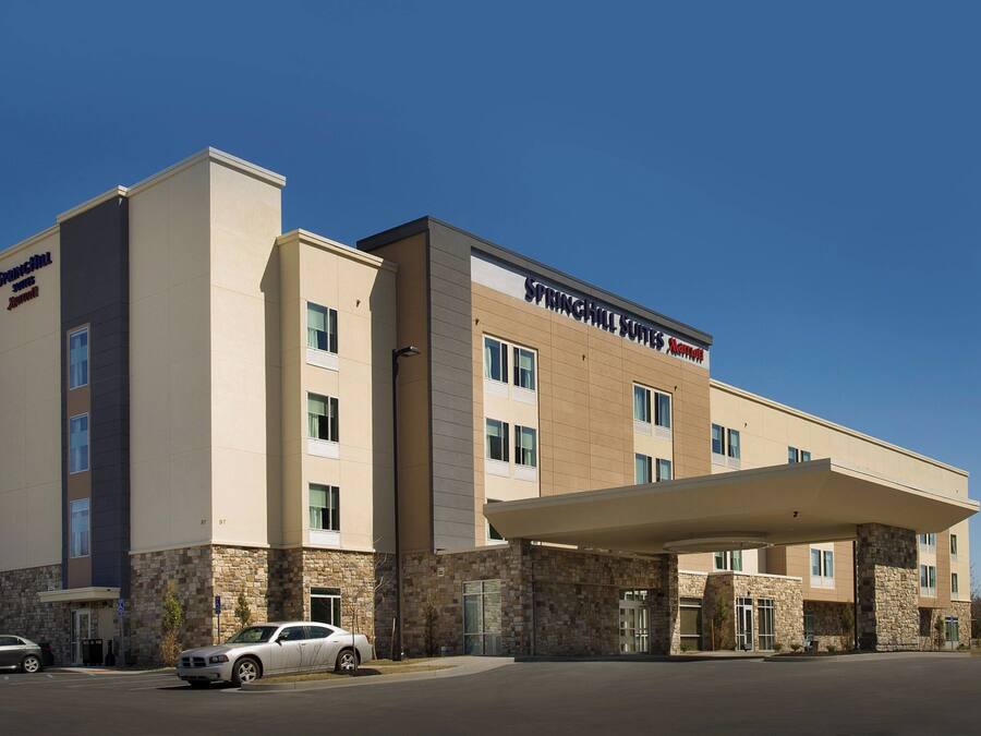 A hotel with a stone facade, multiple floors, and a covered entrance.