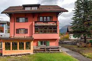 Un edificio de dos pisos con un letrero que dice "Chalet SPECIALE" y un letrero de restaurante debajo.