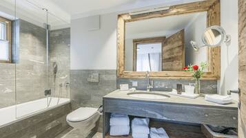 A modern bathroom with a glass shower enclosure, a wooden-framed mirror, and a built-in sink with a vanity.