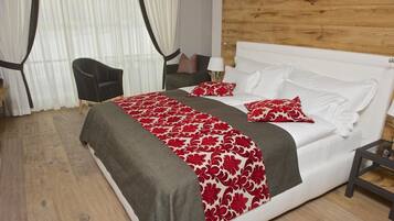 A hotel room with a bed, a chair, a nightstand, and a wooden wall.