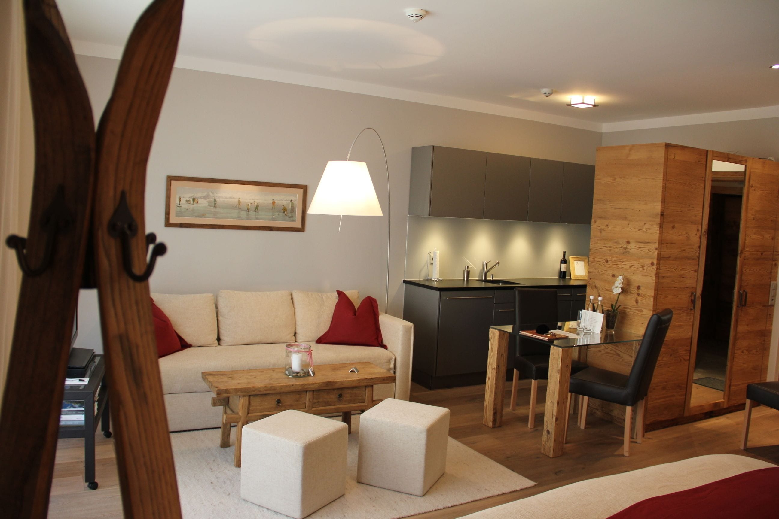 Una sala de estar moderna con un sofá, otomanas, una mesa de centro y un comedor con una mesa y sillas.