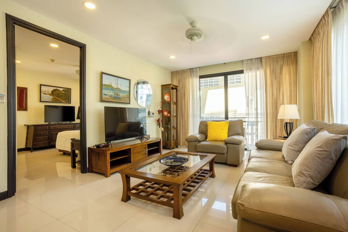 A living room with a sofa, a coffee table, a TV, and a bookshelf.