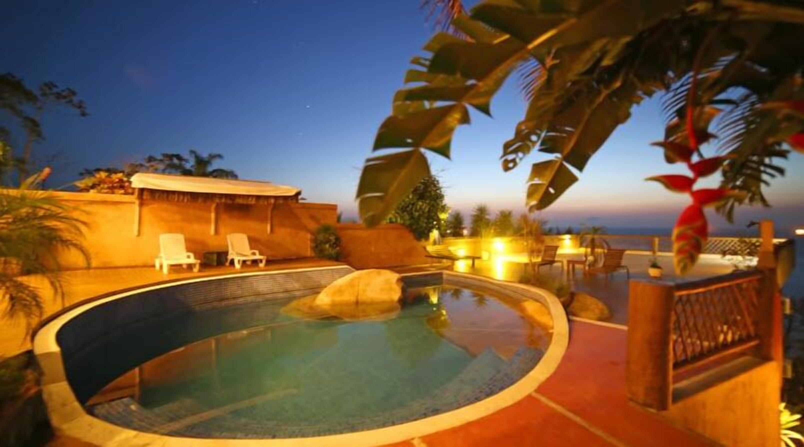 Una piscina al aire libre, sombrillas, sillones reclinables de piscina