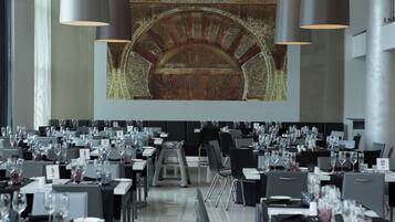 Un salón de conferencias con filas de mesas, cada una identificada con un número.