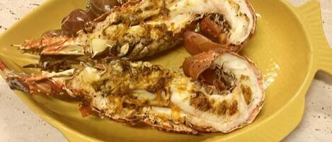 A yellow plate with two cooked lobsters.