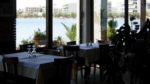 Un restaurant doté d’une terrasse offrant une vue sur un plan d’eau et des bâtiments.