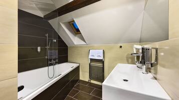 A modern bathroom with a bathtub, a sink, and a shower.