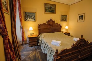A hotel room with a large bed, two bedside tables with lamps, a wooden headboard, and three framed pictures on the walls. - Depandance Edward Kelly (Cesky Krumlov)
