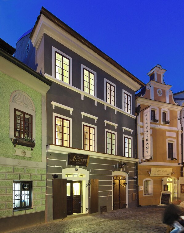 A historic building with a sign for Hotel Alchymy Riverside, featuring a traditional facade with multiple windows and a corner entrance. - Depandance Edward Kelly (Cesky Krumlov)