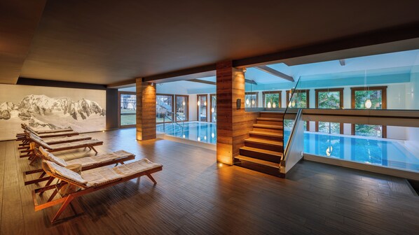 A spacious indoor area with a pool, wooden flooring, and a staircase leading to an upper level. - Montana Lodge & Spa, by R Collection Hotels (La Thuile)