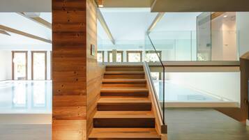 Un intérieur moderne avec un escalier en bois menant à une rambarde en verre.