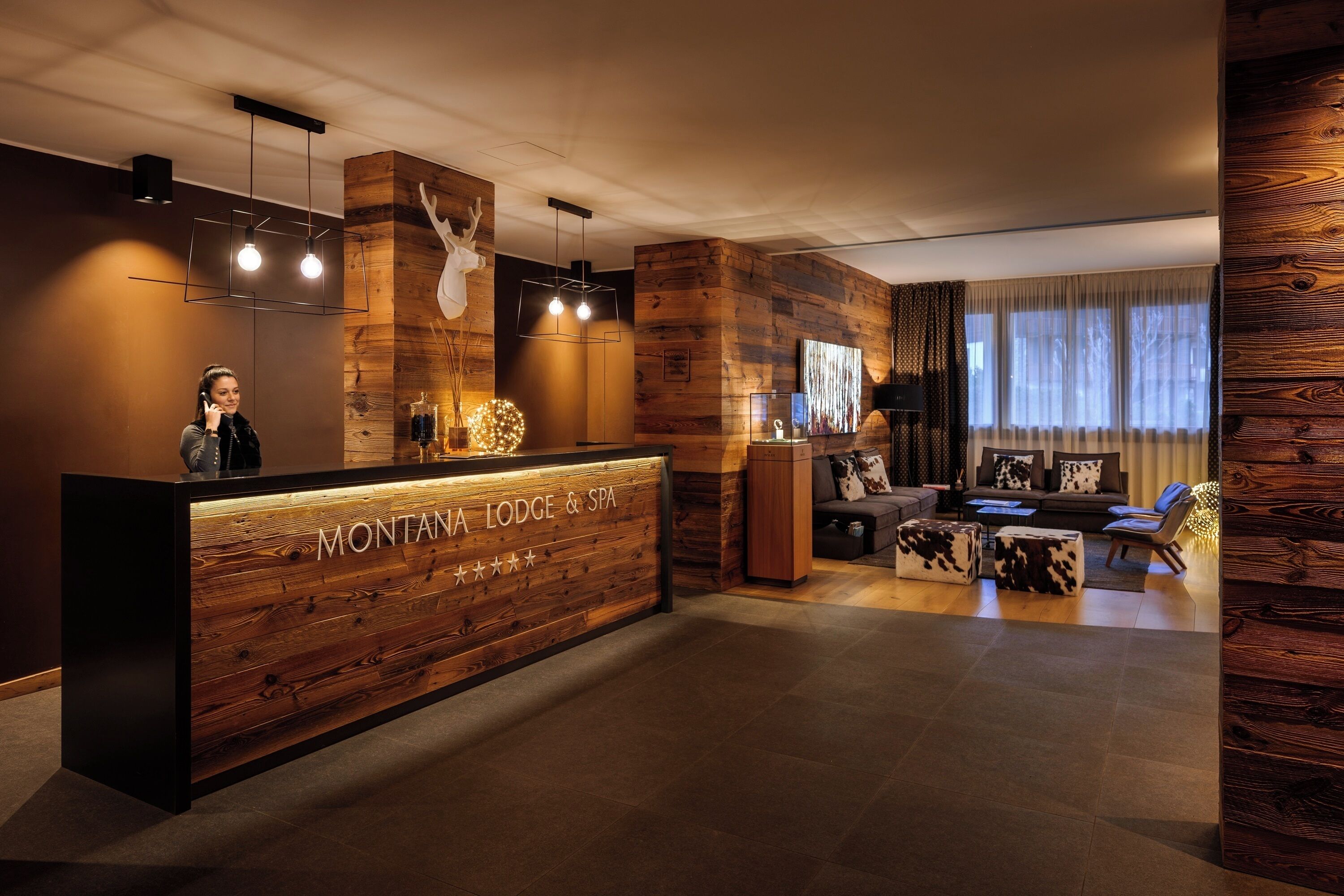 Un comptoir d’accueil avec un revêtement en bois et une enseigne indiquant « MONTANA LODGE & SPA ».