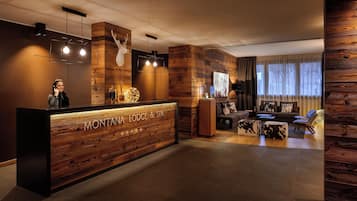 Un comptoir d’accueil avec un revêtement en bois et une enseigne indiquant « MONTANA LODGE & SPA ».