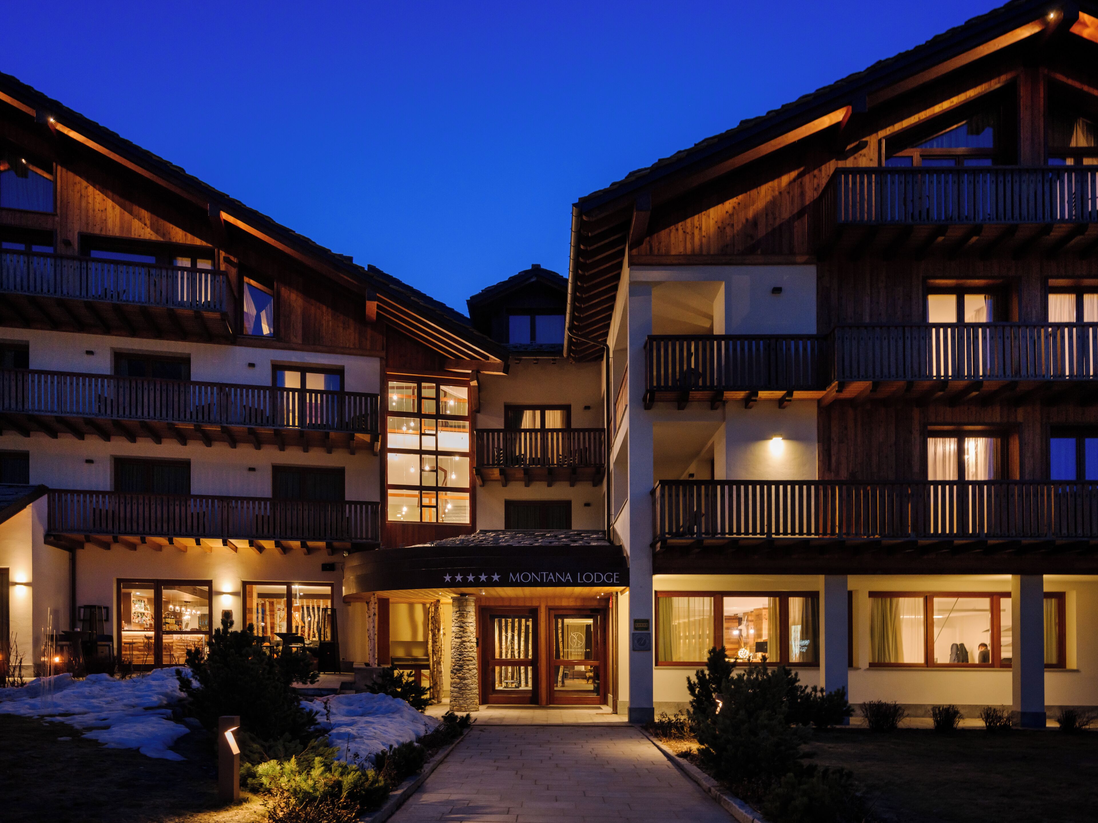 A multi-story hotel with a central entrance and balconies on each floor.