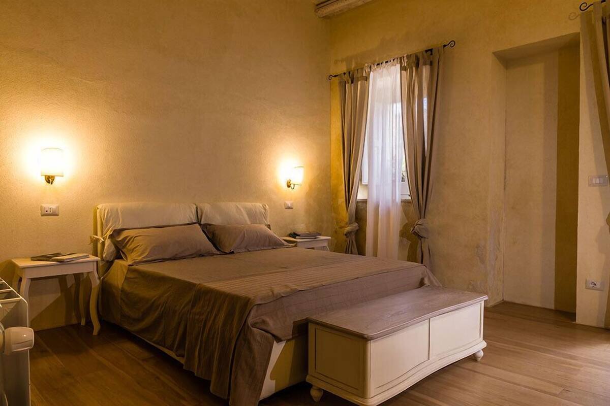 Een slaapkamer met een bed, nachtkastjes en twee wandlampen.