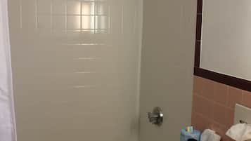 A bathroom with a bathtub, toilet, and a shower area.