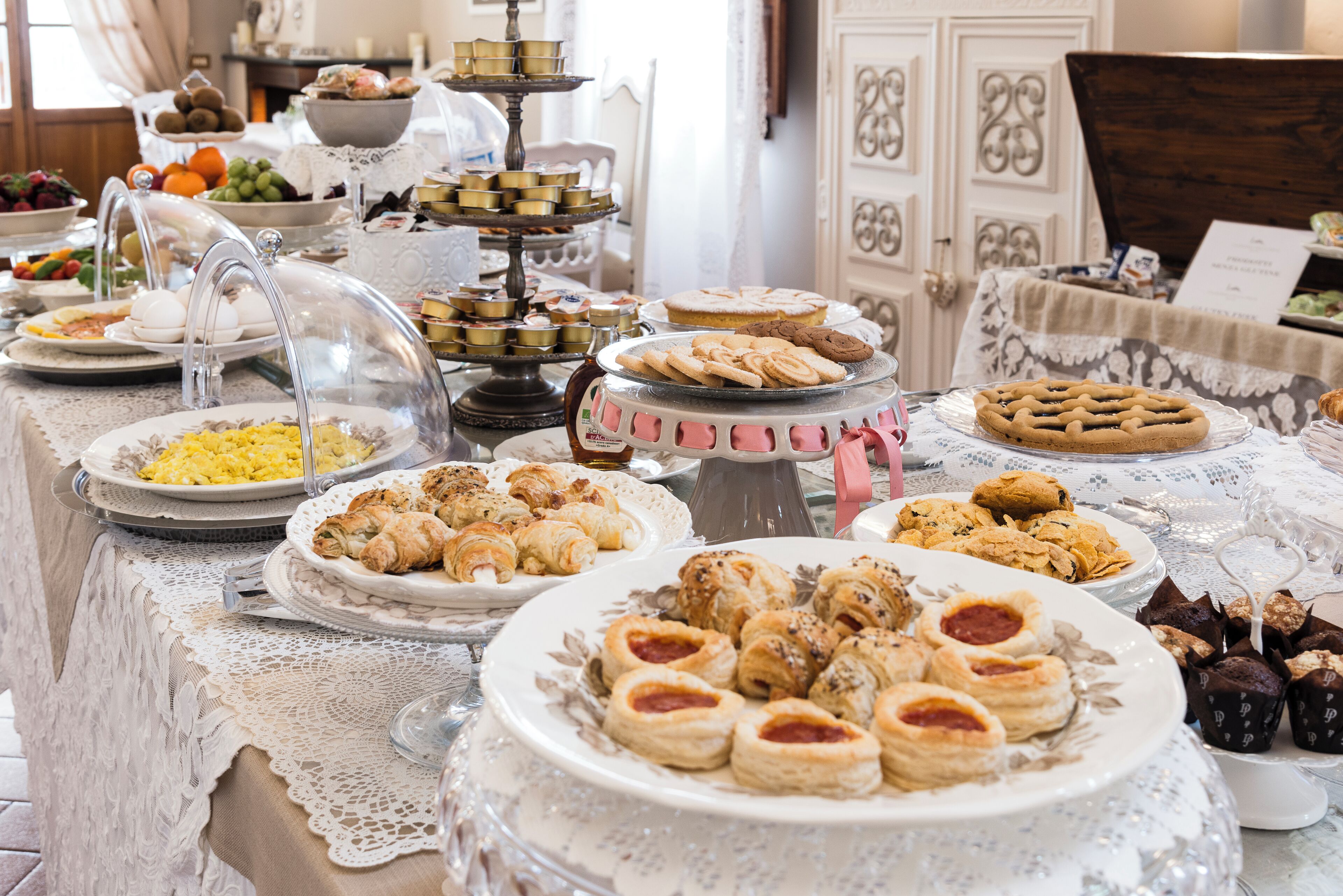 A buffet table with various food items and a decorative centerpiece.