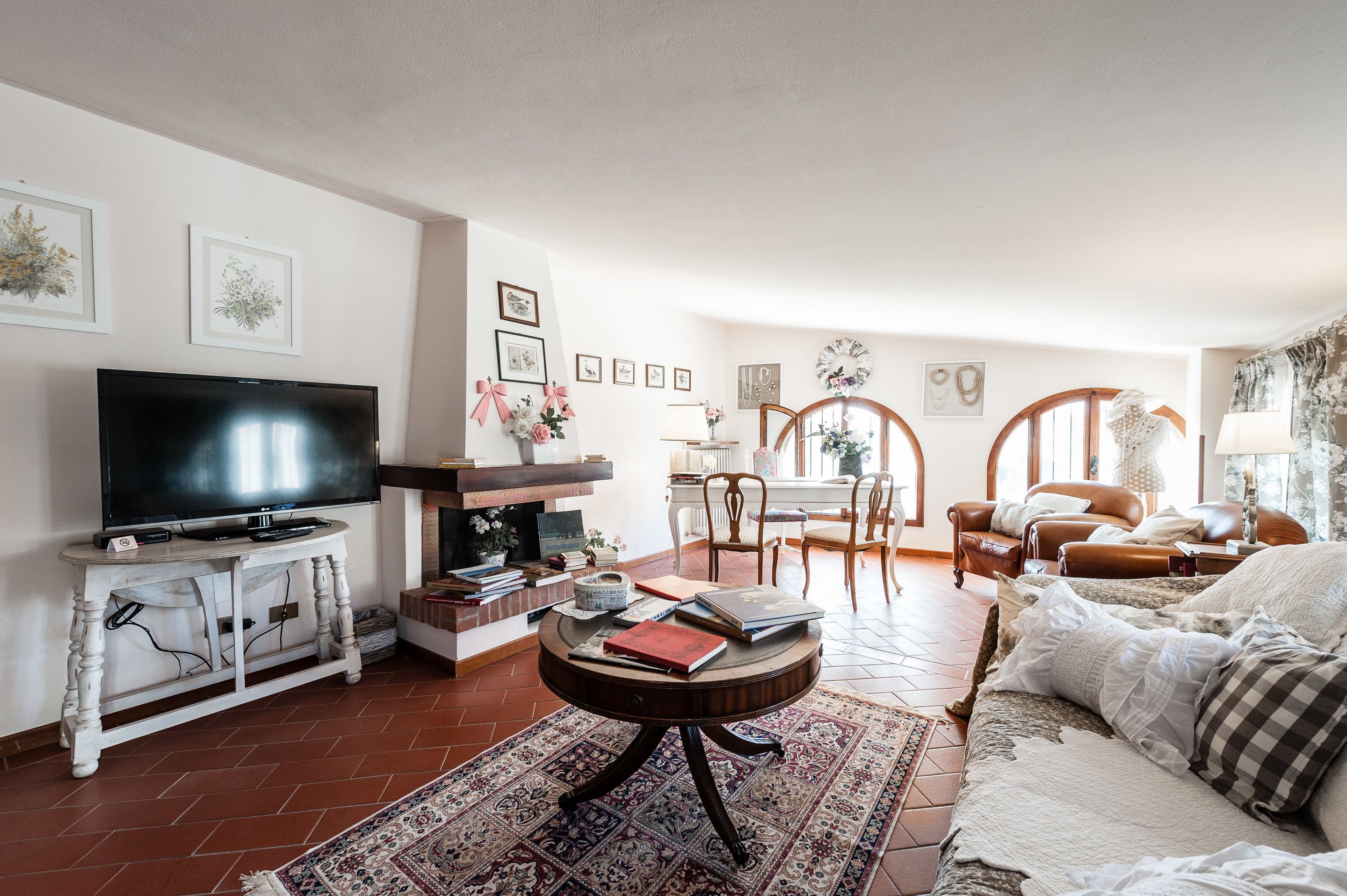 A living room with a TV, fireplace, dining area, and seating.