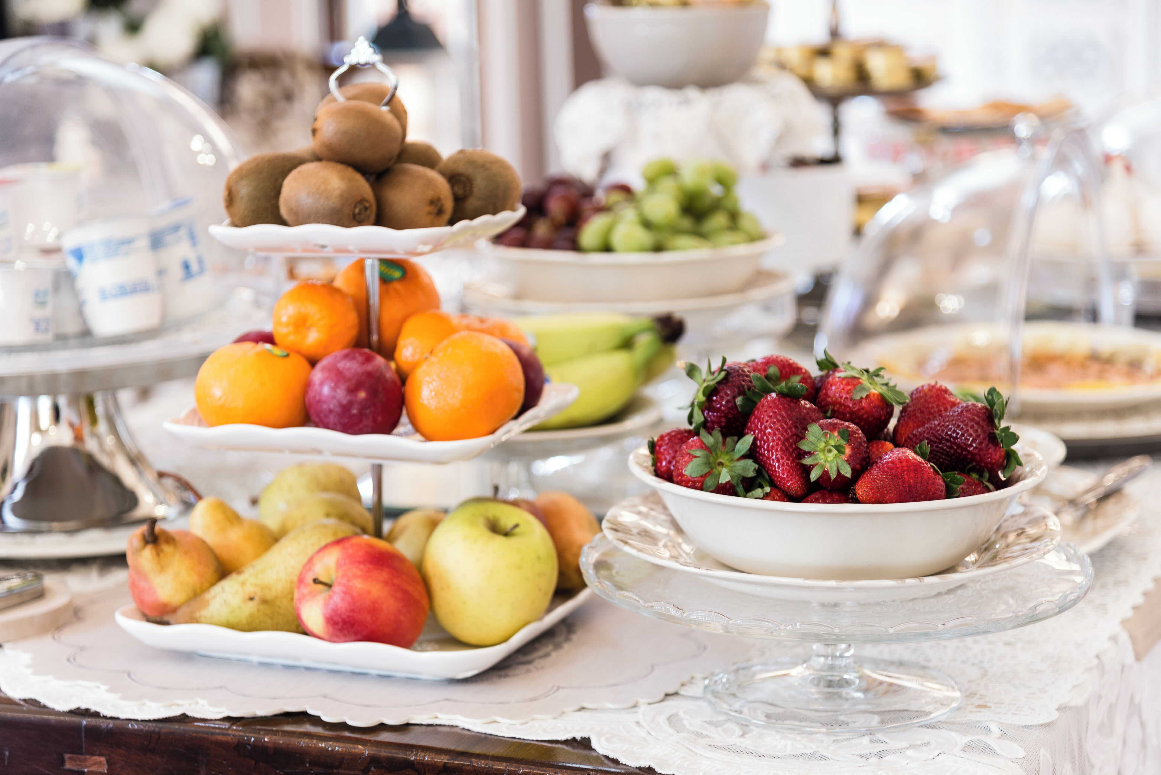 A buffet table with various fruits and pastries.