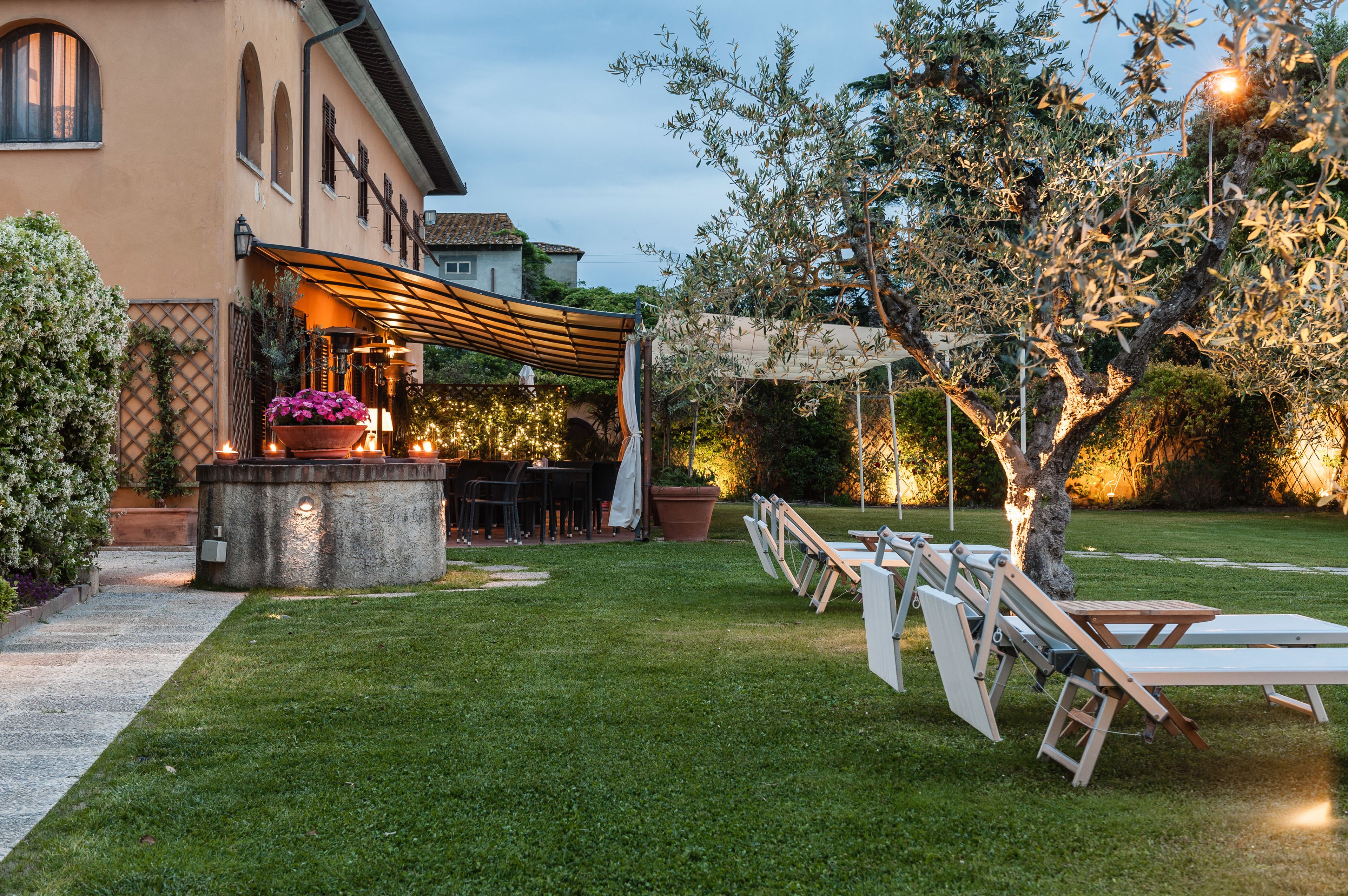 An outdoor patio with a pergola, seating, and a small bar area.