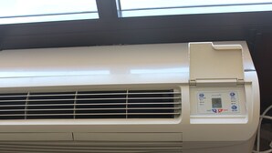 A white air conditioning unit with a control panel displaying temperature settings and a timer. - Tourway Inn (Birmingham)