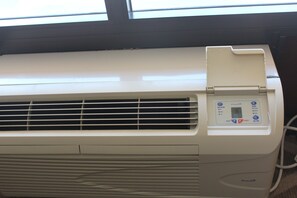 A white air conditioning unit with a control panel displaying temperature settings and a timer.