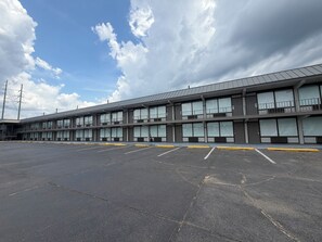 A multi-story hotel with a parking lot in front. - Tourway Inn (Birmingham)