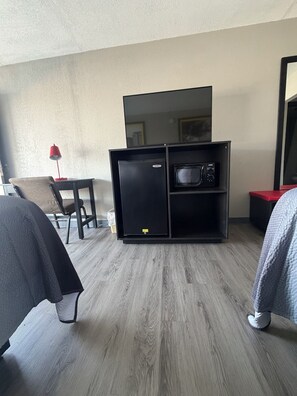 A hotel room with a kitchenette, a desk, a chair, and a bed. - Tourway Inn (Birmingham)