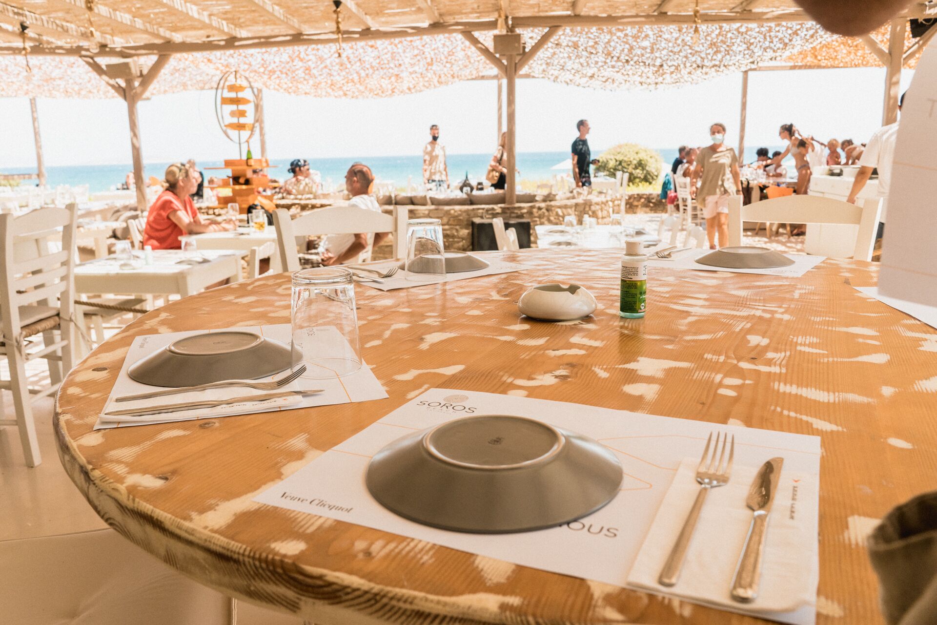 Une table ronde dressée pour le dîner, avec vue sur la mer.