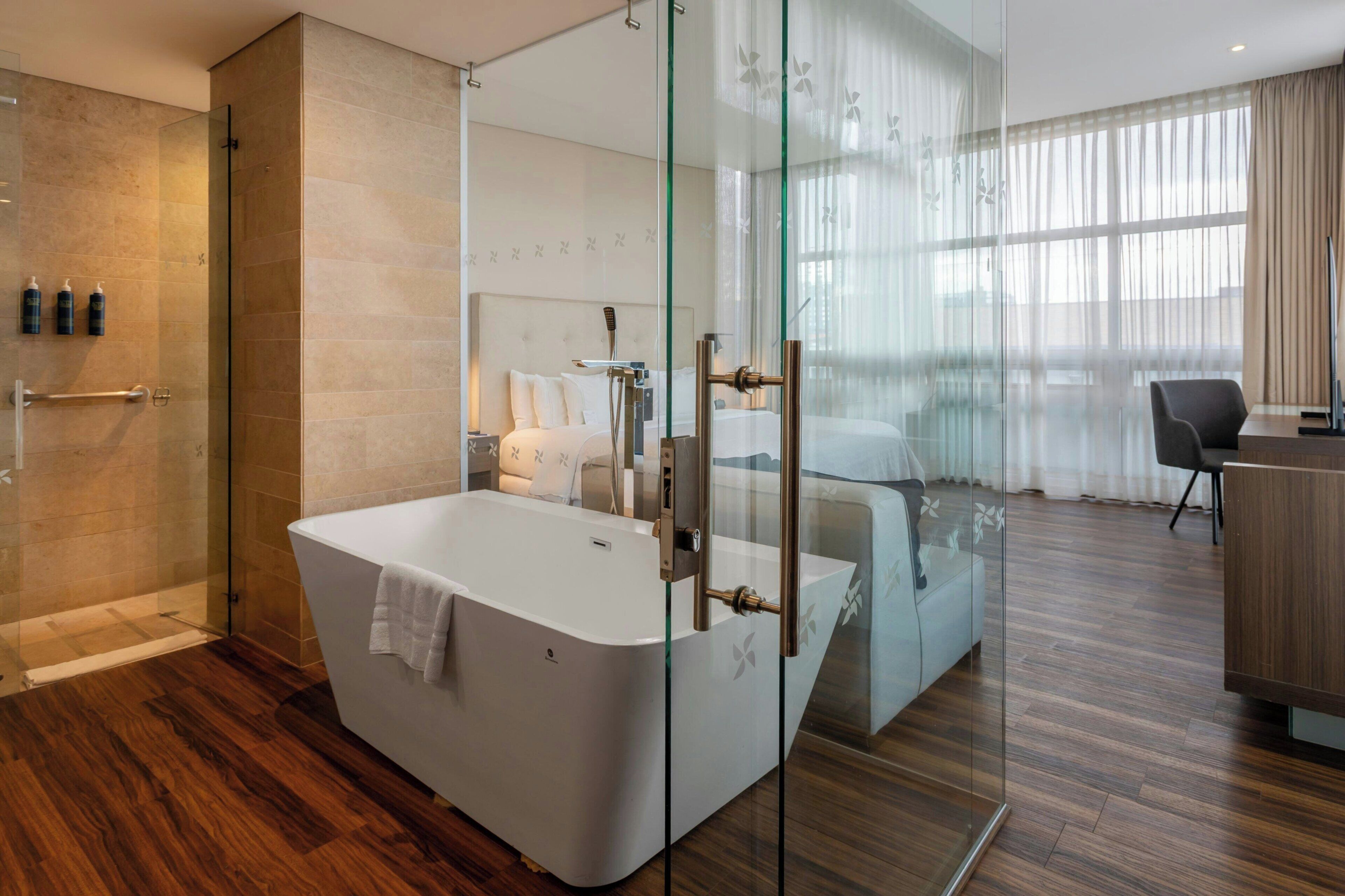 A modern bathroom with a freestanding bathtub, a glass shower enclosure, and a visible shower head.