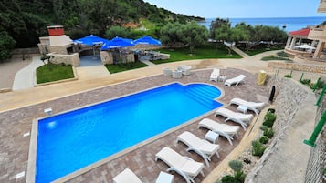 Seasonal outdoor pool, a waterfall pool, pool umbrellas, pool loungers