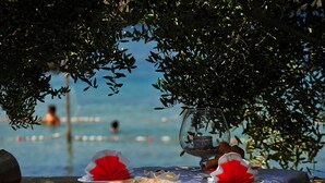 Mesa lista para comer con vista a una piscina y un vaso de agua.