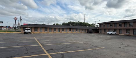 Un motel doté d’un parking, d’un bâtiment à un seul étage et d’une enseigne bien visible indiquant la présence d’un restaurant.
