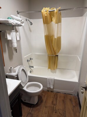 A bathroom with a bathtub, toilet, and sink.