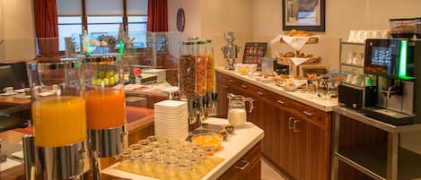 Um buffet de café da manhã com diversos alimentos e bebidas.