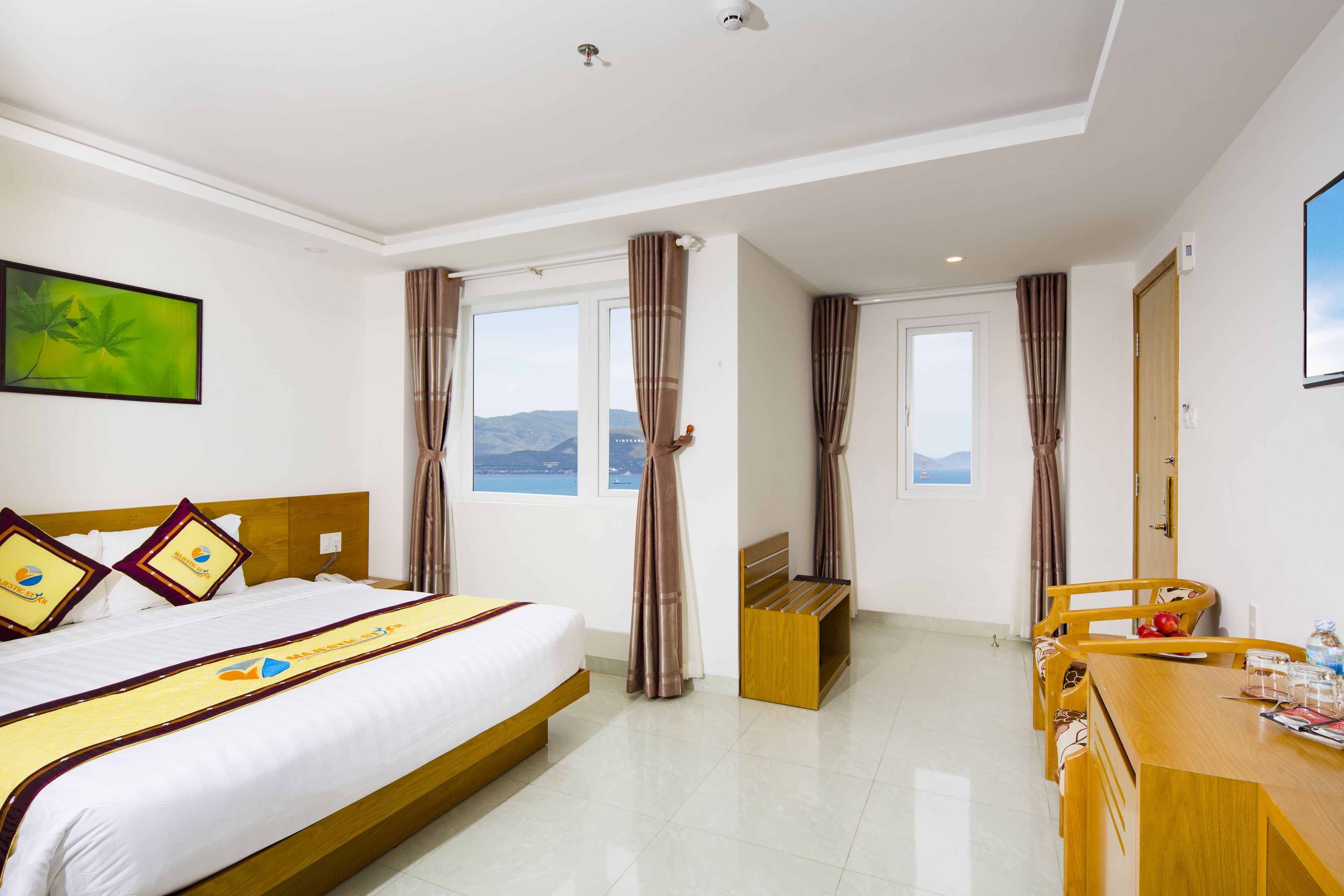 A hotel room with a bed, a desk, and a view of the mountains.