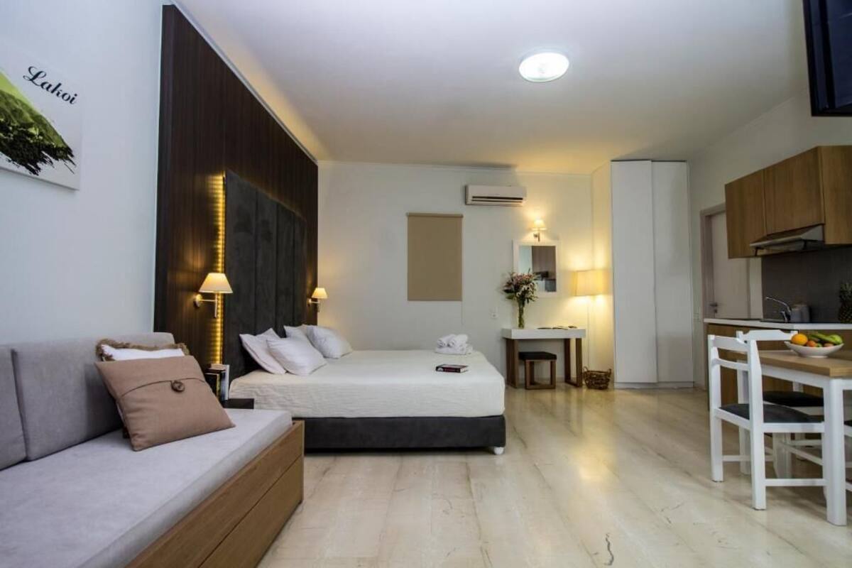 Ein kleines Hotelzimmer mit Bett, Nachttisch und einer kleinen Küchenzeile.