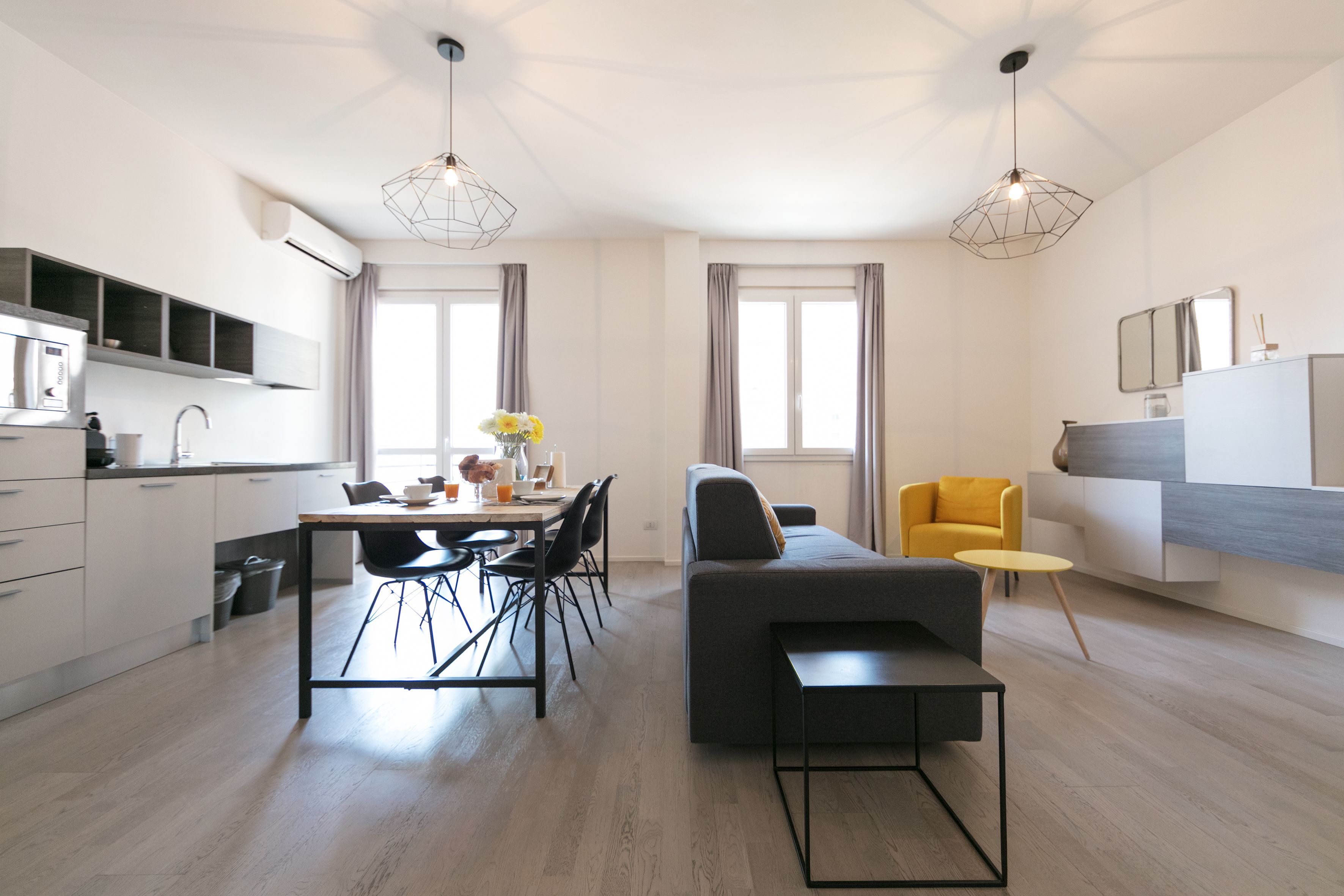 Una cocina moderna con comedor, un sofá y un sillón amarillo.