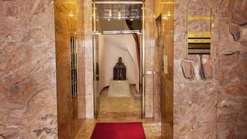 Un ingresso con pavimento in marmo e una moquette rossa che conduce alla reception.