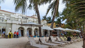 A beachside hotel with lounge chairs and umbrellas, palm trees, and a building labeled "SANDS". - Boracay Sands Hotel (Boracay Island)