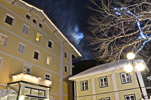 A multi-story building with balconies and windows, under a night sky with visible stars. - Hotel Helenenburg (Bad Gastein)