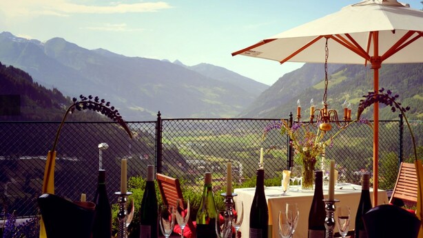 A table set for a meal with a view of mountains, a fence, and a candelabra. - Hotel Helenenburg (Bad Gastein)