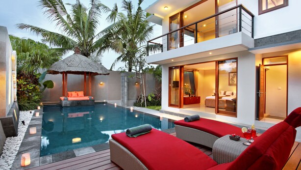 A modern villa with a swimming pool, outdoor seating, and a well-lit interior. - Villa Lea (Tabanan)