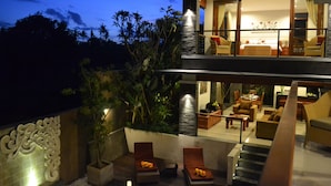 A modern two-story house with a balcony, a dining area, and a living room. - Villa Lea (Tabanan)