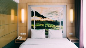 A hotel room with a bed, two bedside tables, a telephone, and a painting of a landscape. - Tebu Hotel Bandung (Bandung)